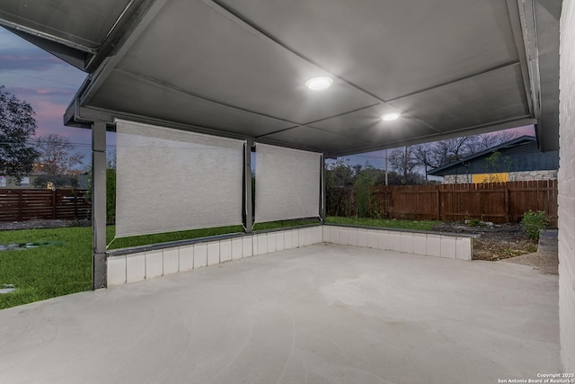 patio terrace at dusk featuring fence