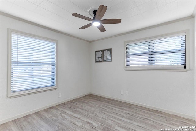 empty room with baseboards, crown molding, light wood finished floors, and ceiling fan