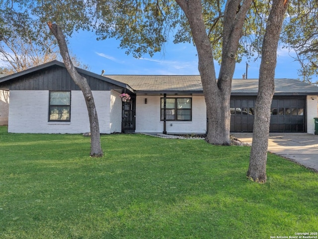 view of front of house with a garage, a front lawn, concrete driveway, and brick siding