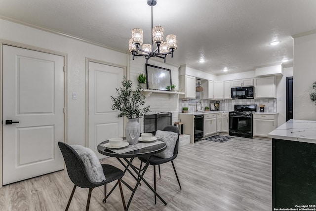 dining room featuring an inviting chandelier, a textured ceiling, crown molding, and light hardwood / wood-style flooring