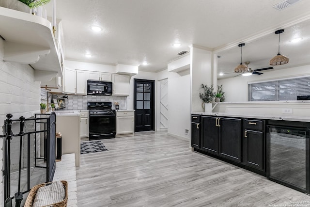 kitchen with black appliances, hanging light fixtures, beverage cooler, and white cabinets