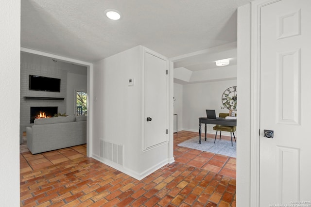 hall featuring a textured ceiling