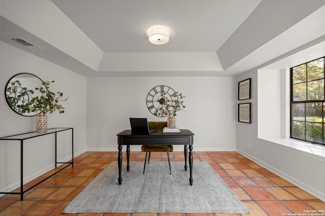 home office featuring a raised ceiling and tile patterned flooring