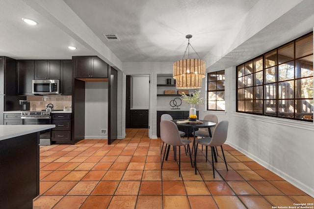 tiled dining room with an inviting chandelier