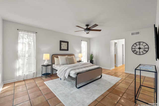 tiled bedroom featuring multiple windows and ceiling fan