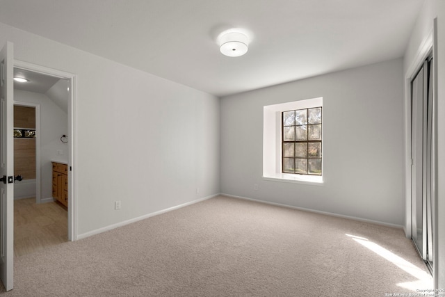 unfurnished bedroom with light colored carpet and a closet