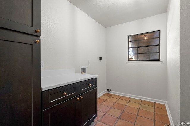 laundry area featuring cabinets, hookup for a washing machine, electric dryer hookup, and light tile patterned floors