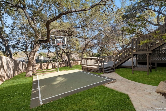 view of basketball court with a yard