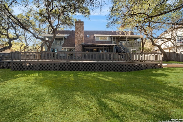 rear view of house featuring a yard and a wooden deck