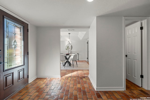 foyer entrance with a textured ceiling and plenty of natural light