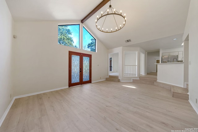 unfurnished living room featuring light hardwood / wood-style flooring, french doors, high vaulted ceiling, an inviting chandelier, and beamed ceiling