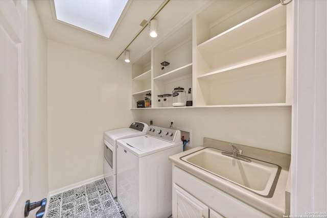 washroom featuring sink, track lighting, a skylight, and separate washer and dryer