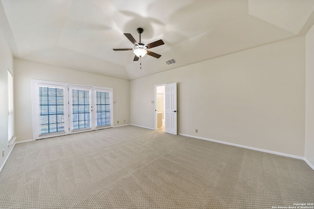 spare room with a raised ceiling, light carpet, ceiling fan, and vaulted ceiling