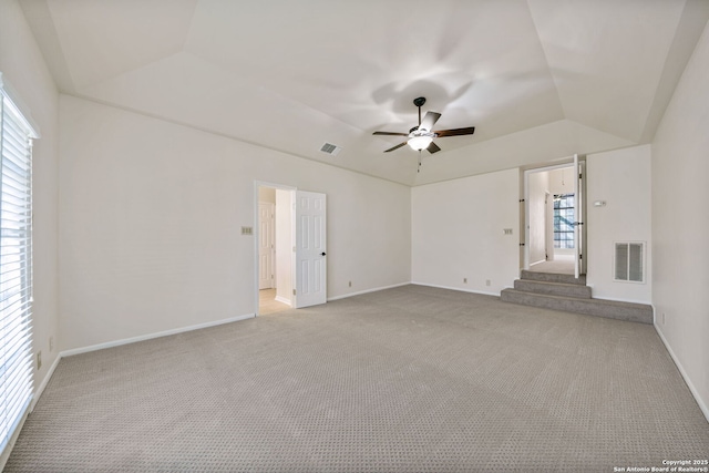 spare room featuring lofted ceiling, ceiling fan, and light carpet