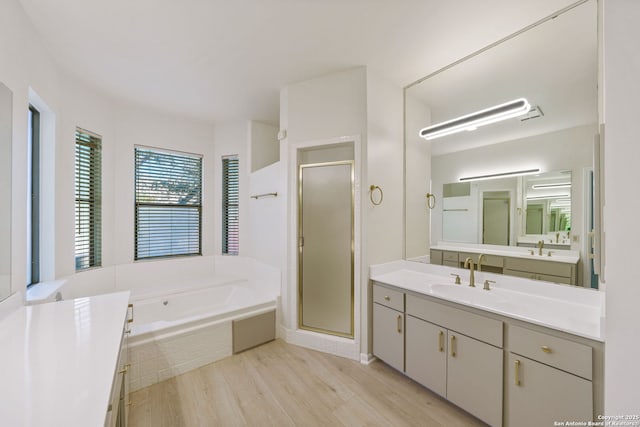 bathroom featuring shower with separate bathtub, wood-type flooring, and vanity