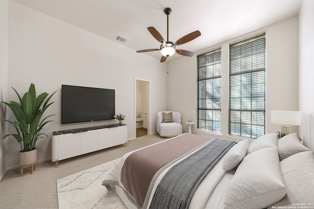 carpeted bedroom featuring ensuite bath and ceiling fan