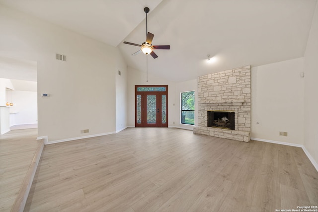 unfurnished living room featuring ceiling fan, light hardwood / wood-style flooring, a stone fireplace, and high vaulted ceiling