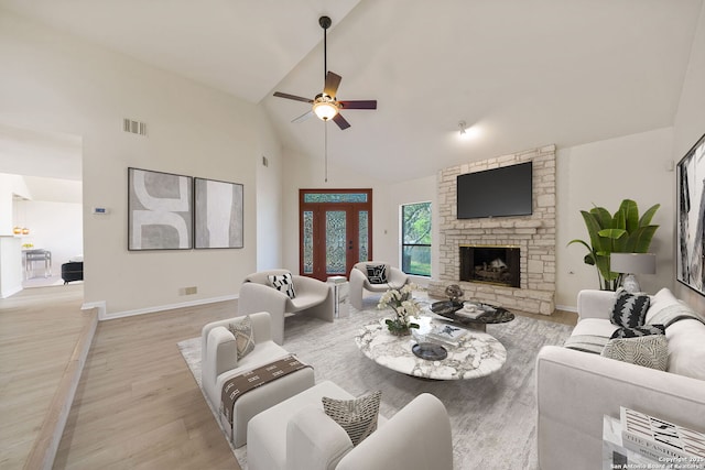 living room with lofted ceiling, a fireplace, light wood-type flooring, and ceiling fan