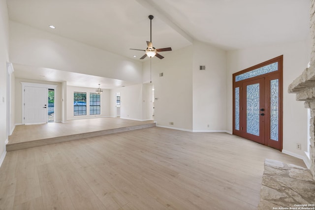 unfurnished living room with ceiling fan, light wood-type flooring, french doors, and high vaulted ceiling