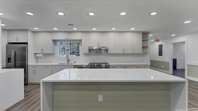 kitchen featuring a kitchen island, stainless steel fridge, stove, and sink