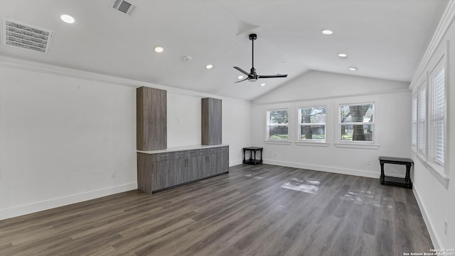 unfurnished living room with vaulted ceiling, dark wood-type flooring, ceiling fan, and ornamental molding