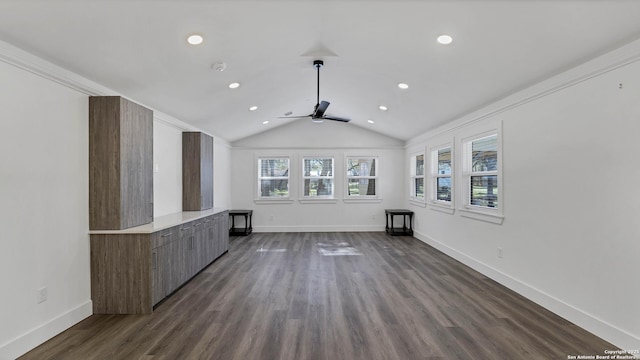 unfurnished living room with vaulted ceiling, dark wood-type flooring, ceiling fan, and ornamental molding