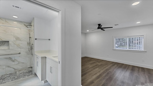 bathroom featuring hardwood / wood-style flooring, a shower with door, ceiling fan, and vanity