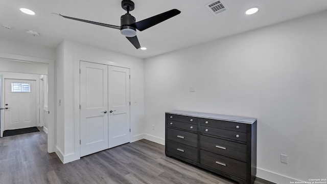 unfurnished bedroom featuring ceiling fan, a closet, and hardwood / wood-style flooring