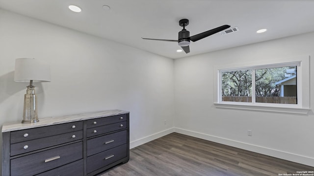 unfurnished room featuring dark wood-type flooring and ceiling fan