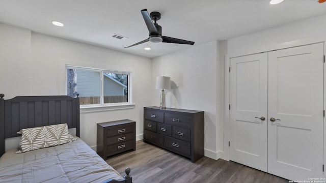 bedroom with ceiling fan, light hardwood / wood-style floors, and a closet