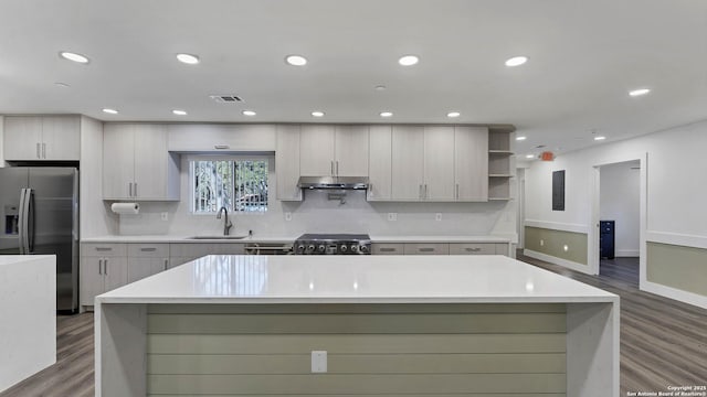 kitchen featuring range, a large island, stainless steel refrigerator with ice dispenser, and sink