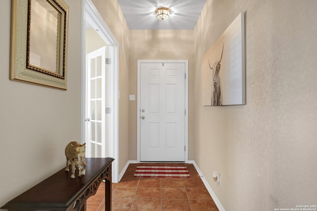 doorway to outside featuring dark tile patterned floors