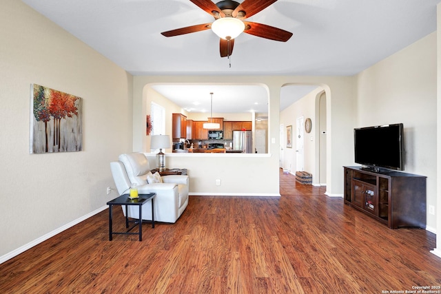 living room with dark hardwood / wood-style flooring and ceiling fan