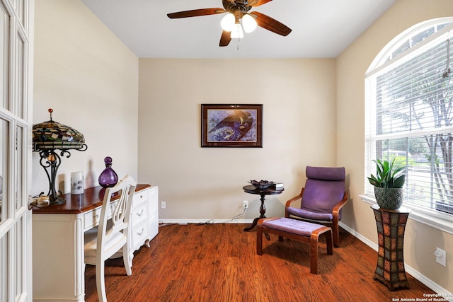 living area with dark wood-type flooring and ceiling fan