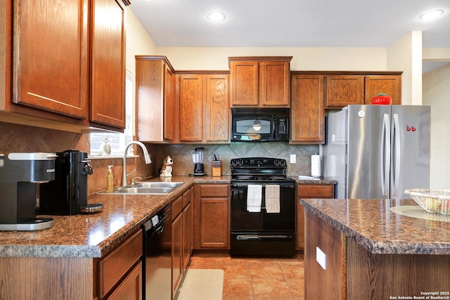 kitchen with dark stone countertops, black appliances, decorative backsplash, and sink