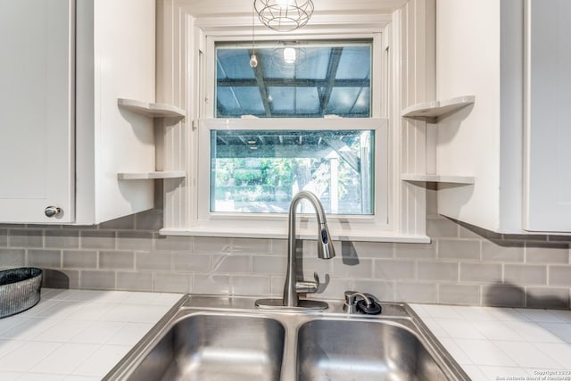 room details with sink, white cabinets, backsplash, and tile counters