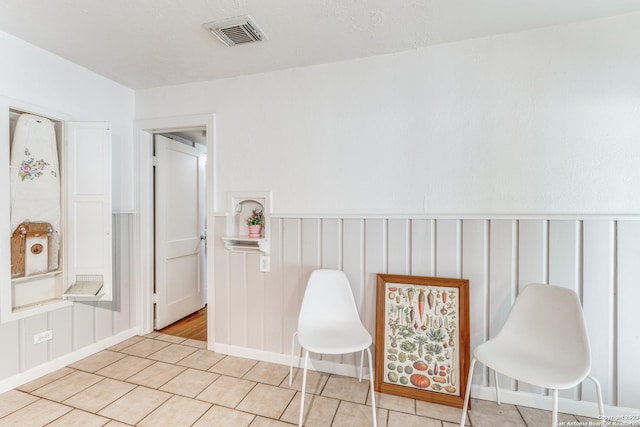 sitting room featuring a textured ceiling and light tile patterned floors