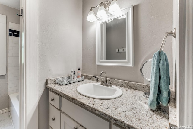 bathroom featuring tiled shower / bath combo and vanity