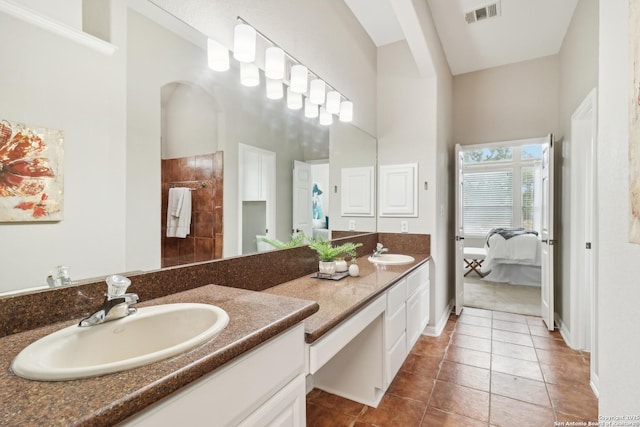 bathroom with tile patterned floors, a towering ceiling, and vanity