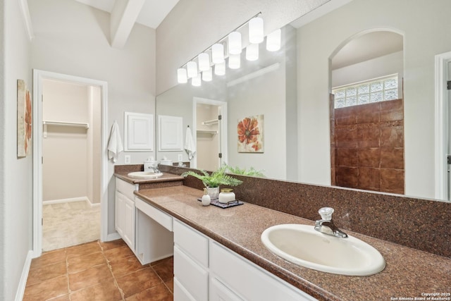 bathroom featuring beamed ceiling, tile patterned floors, and vanity