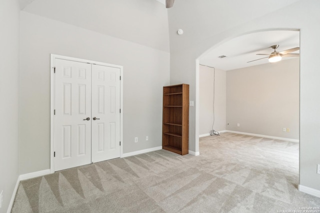 carpeted empty room featuring lofted ceiling and ceiling fan