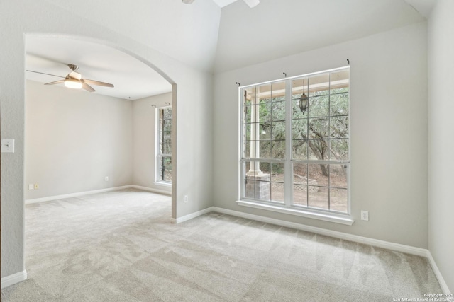 empty room featuring lofted ceiling, light carpet, and ceiling fan