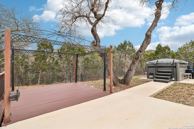 deck featuring fence and a hot tub