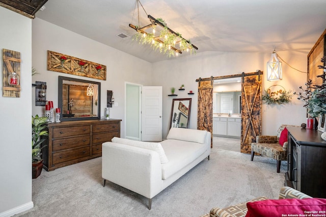 bedroom with lofted ceiling, ensuite bathroom, light carpet, and a barn door