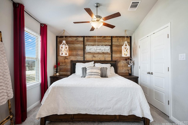 bedroom featuring lofted ceiling, ceiling fan, a closet, and carpet