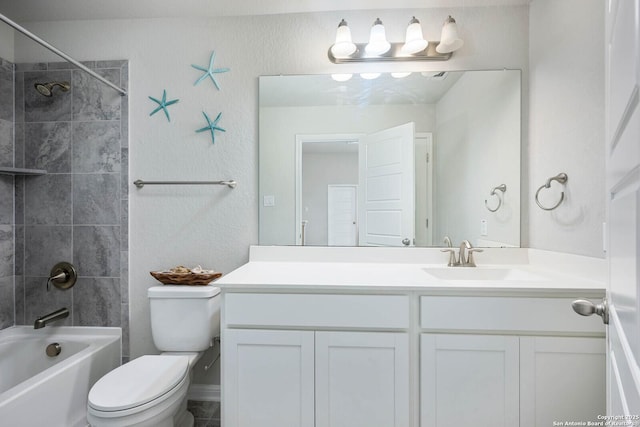 full bathroom featuring toilet, tiled shower / bath, and vanity