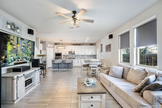 living room featuring ceiling fan and light tile patterned floors