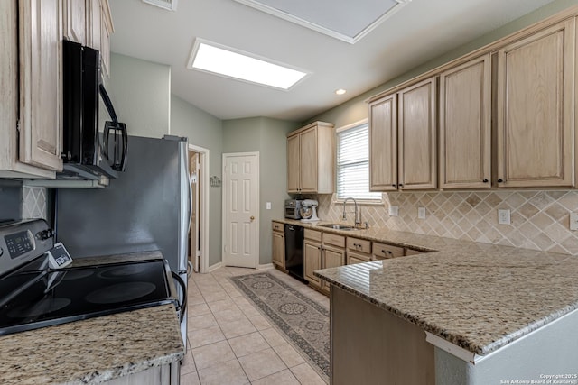 kitchen featuring sink, light tile patterned flooring, black appliances, and light stone counters