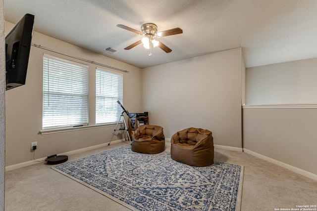 sitting room featuring light colored carpet and ceiling fan