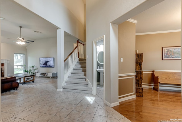 tiled foyer with lofted ceiling, ceiling fan, and ornamental molding